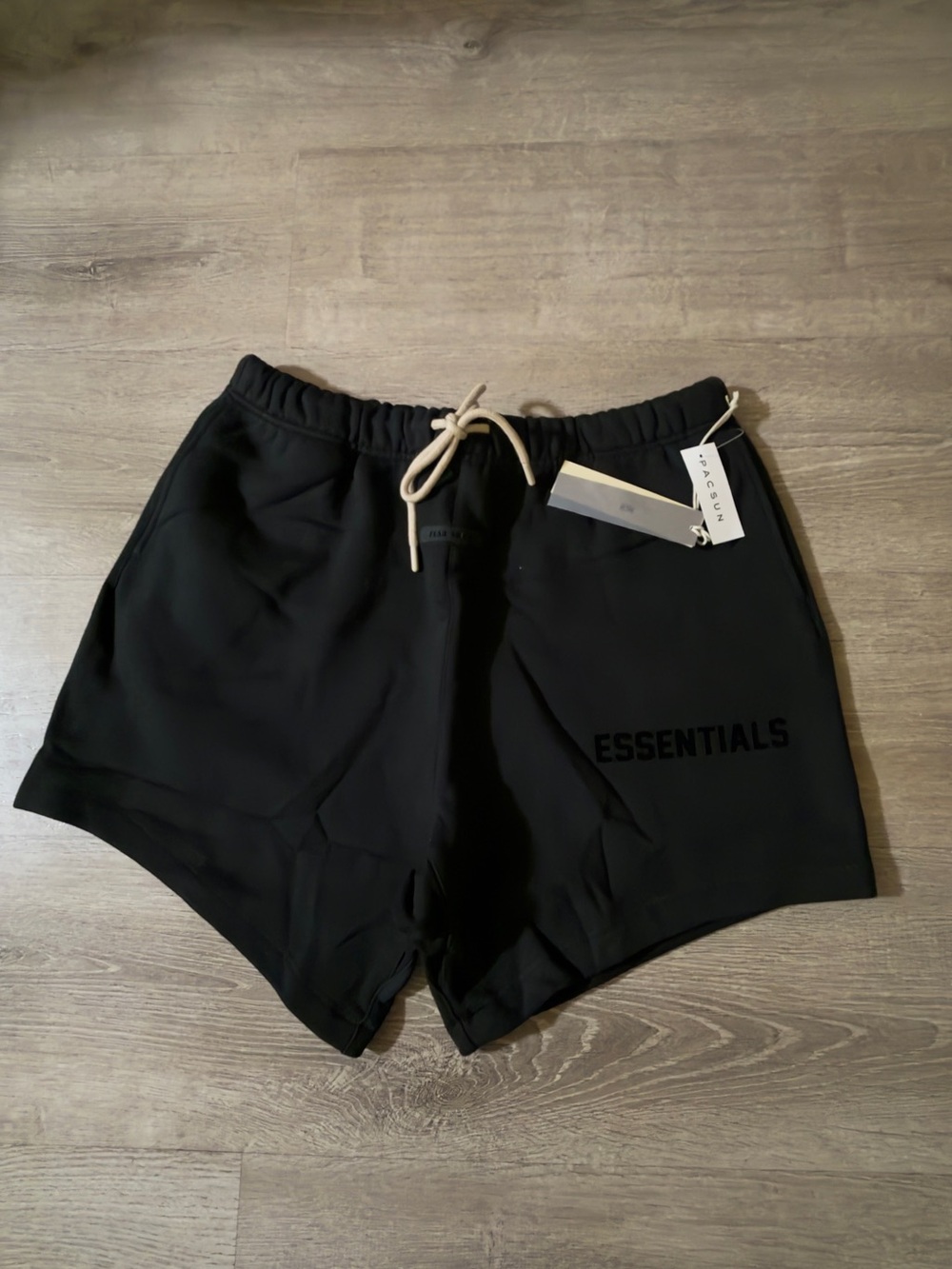 Fear of God
Black ESSENTIALS Graphic Shorts with Beige Drawstrings.